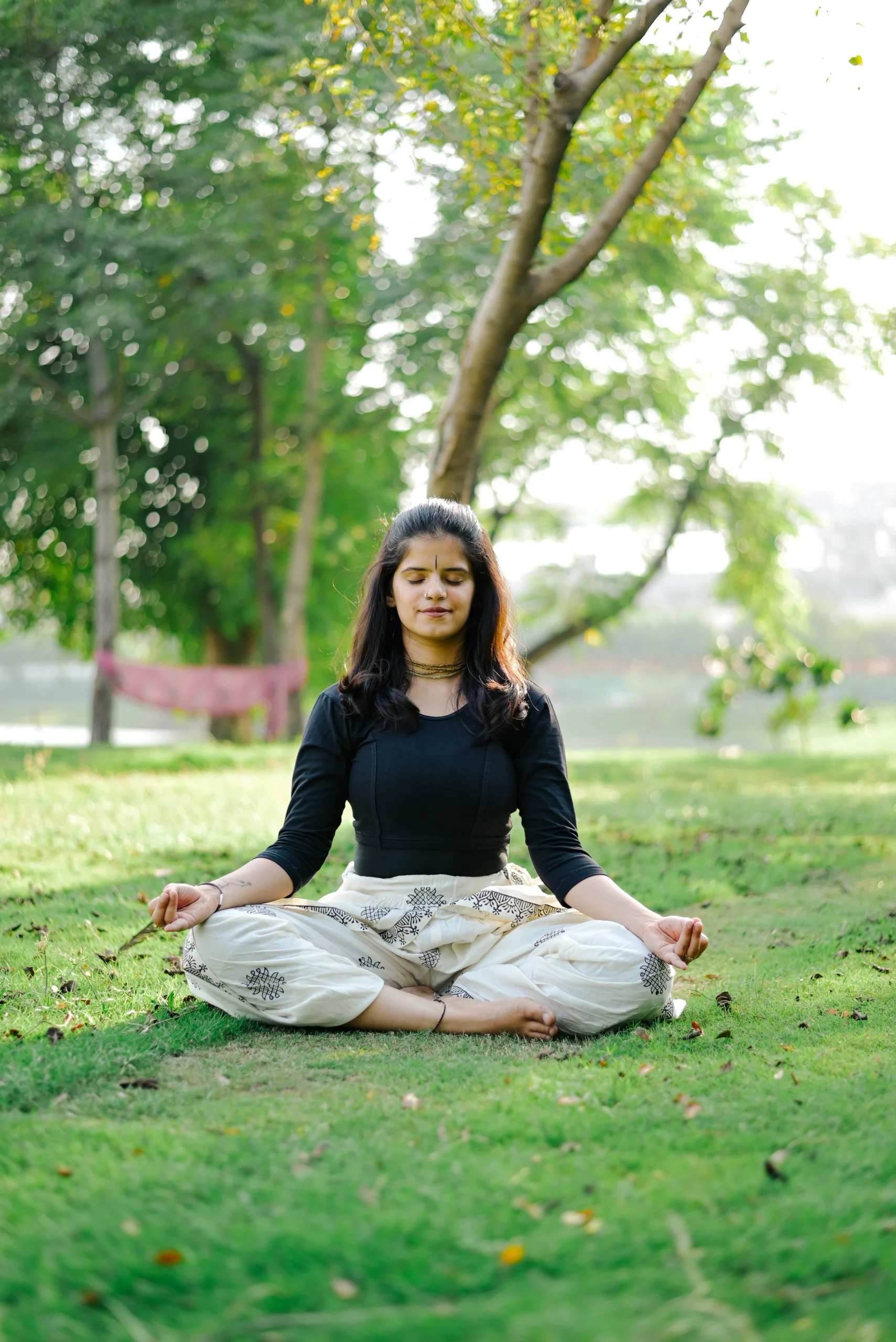 meditating in Padmasana amidst lush greenery, exuding calm and serenity.